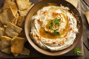 Traditional-middle-eastern-hummus-dip-served-with-pita-bread-chips-olive-oil-and-parsley-garnish
