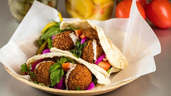 Delicious falafel pita filled with crispy falafel balls, lettuce, cucumber, tomato, and tahini sauce.